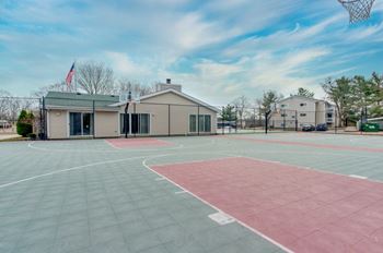 A basketball court with a building in the background.